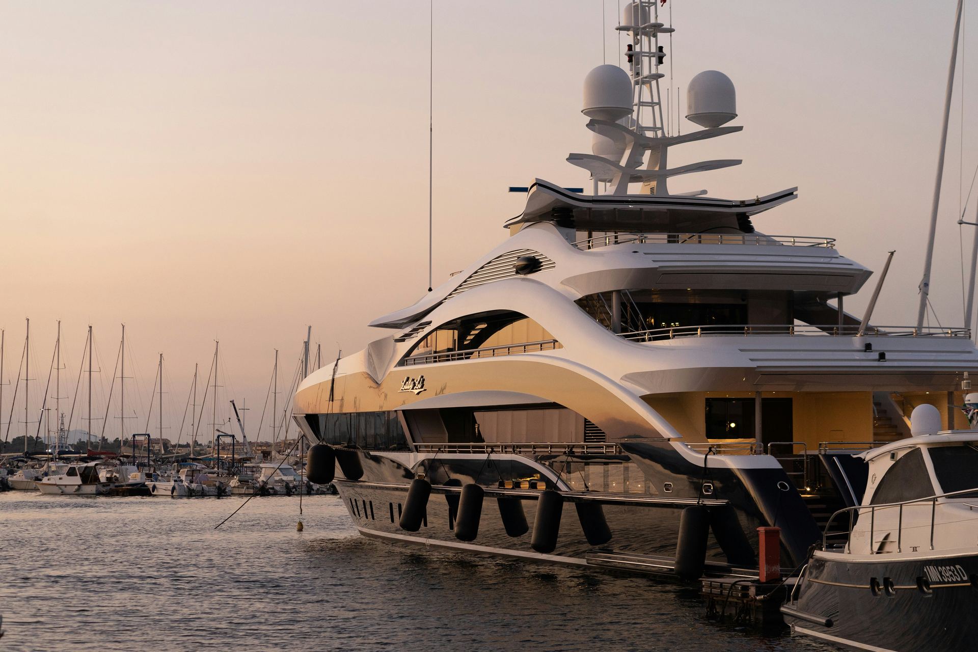 Superyacht moored in a marina at sunset